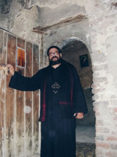 Photo: Paul Perry, father Girgis opening the ancient door leading to the Church of Abu Sefein at Dayr al-Maymun.